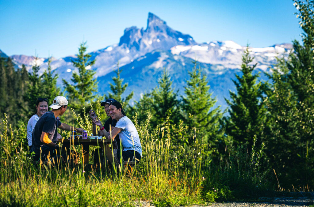 A family enjoy a picnic with the iconic Black Tusk in the background.