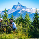 A family enjoy a picnic with the iconic Black Tusk in the background.