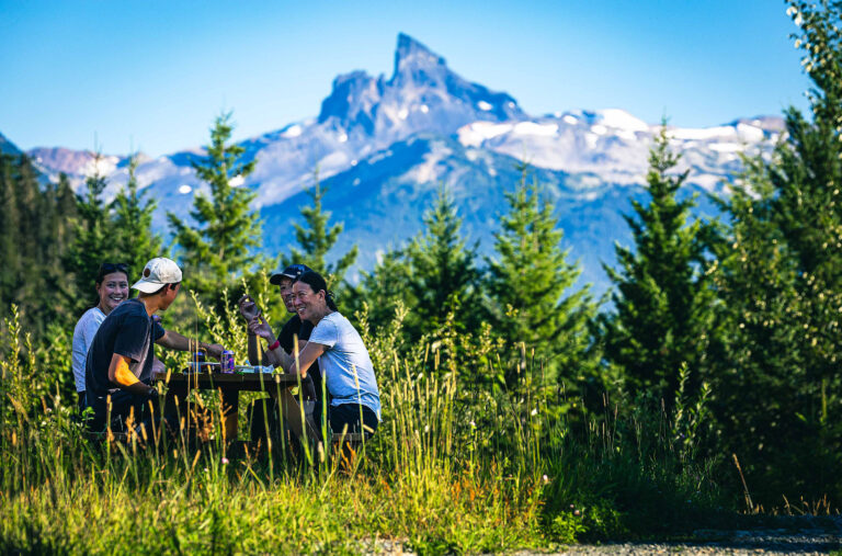 A family enjoy a picnic with the iconic Black Tusk in the background.