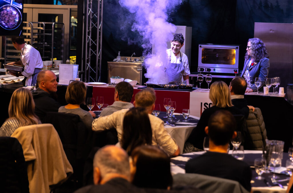 A chef does a cooking demo at the Culinary Stage event at Whistler Cornucopia.