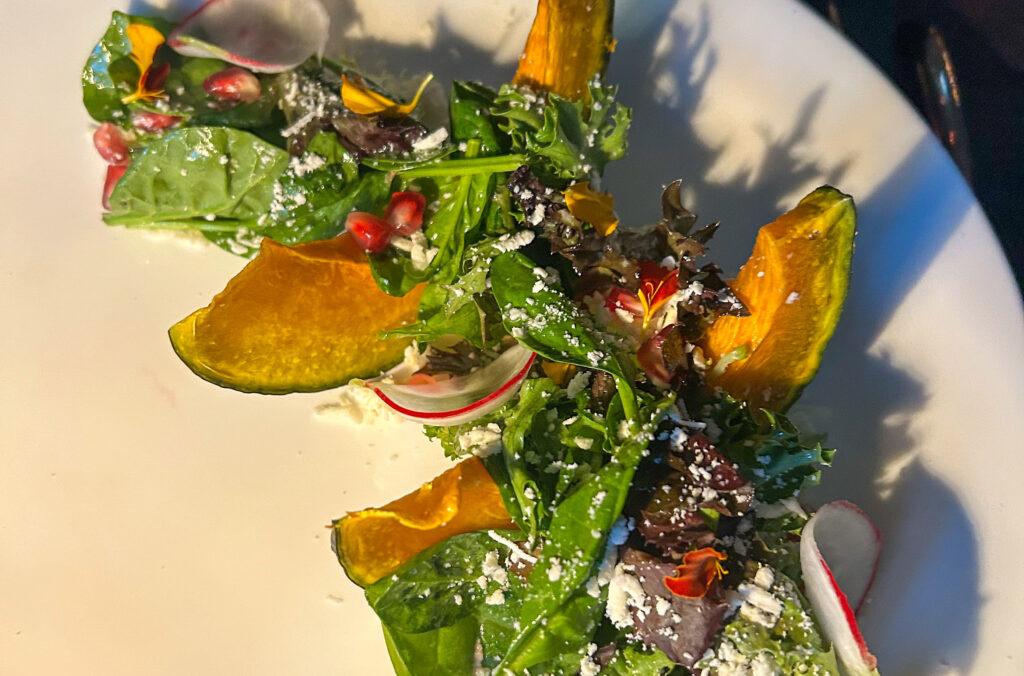 A close up shot of a colourful, fall salad served at Sidecut, Four Seasons Whistler.