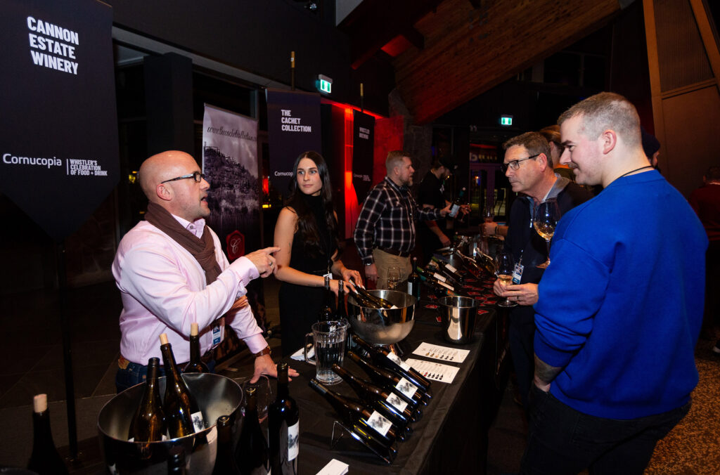 A winemaker talks to event goers about the wine they're pouring at Whistler Cornucopia.