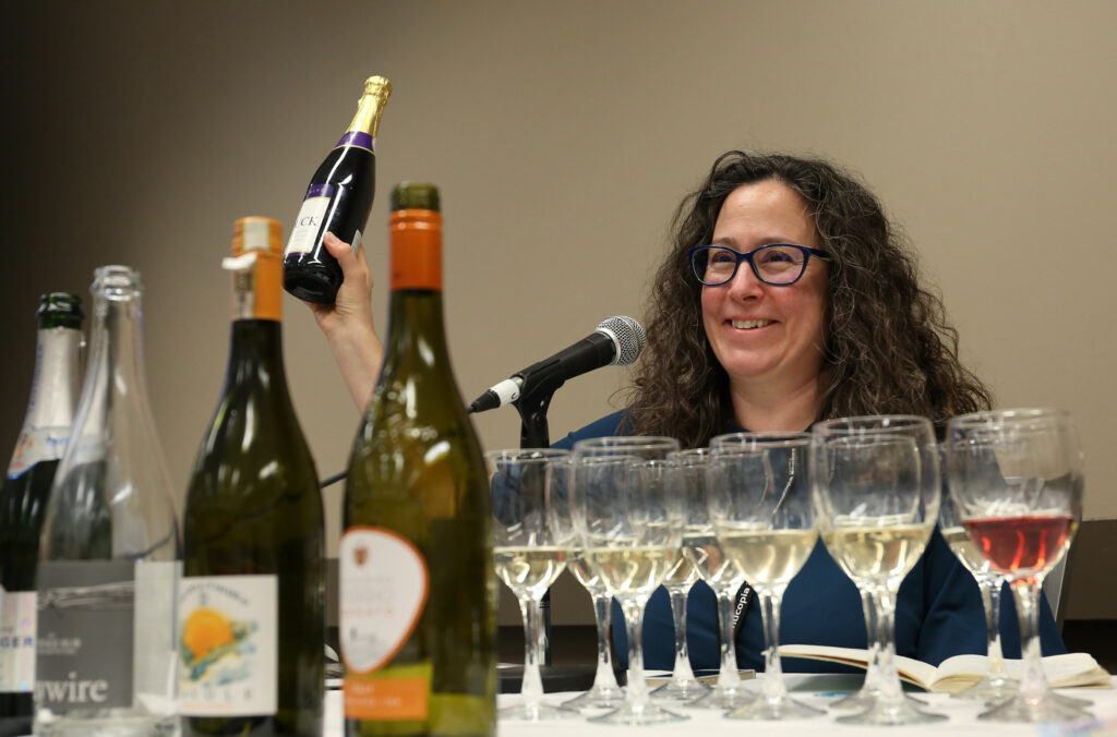 Whistler sommelier, Samantha Rhan, holds up a wine bottle at a drinks seminar during Whistler Cornucopia.