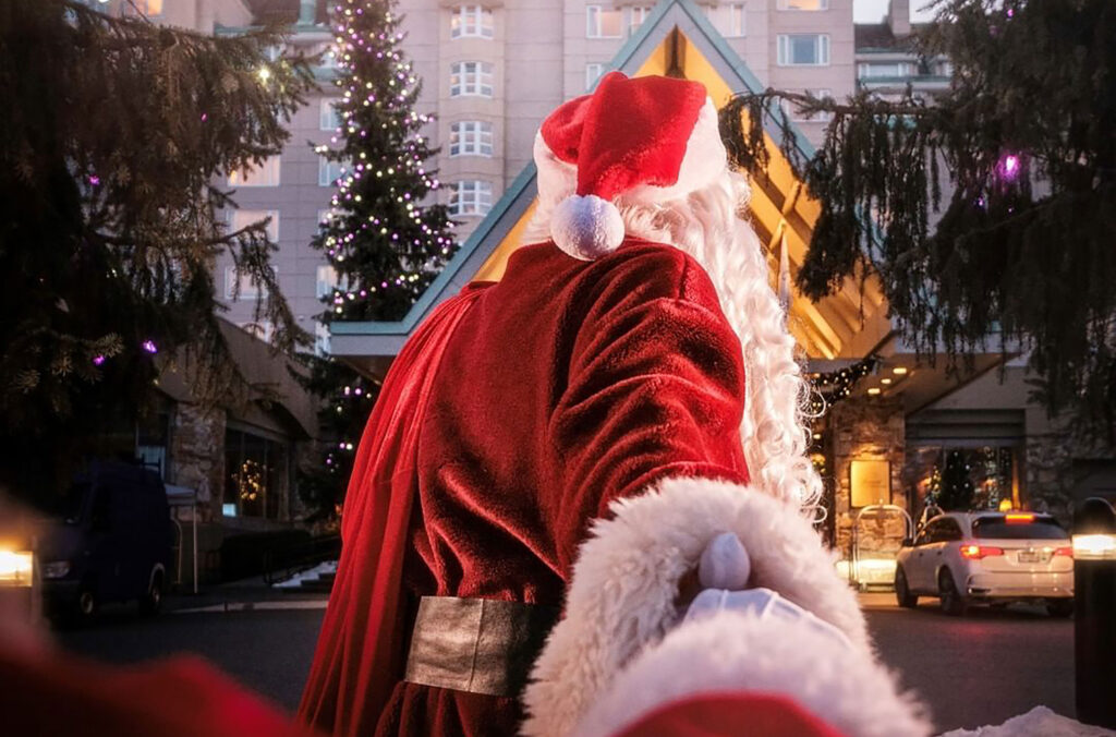 Santa Clause arrives at the Fairmont Whistler carrying a sack, ready to check in.