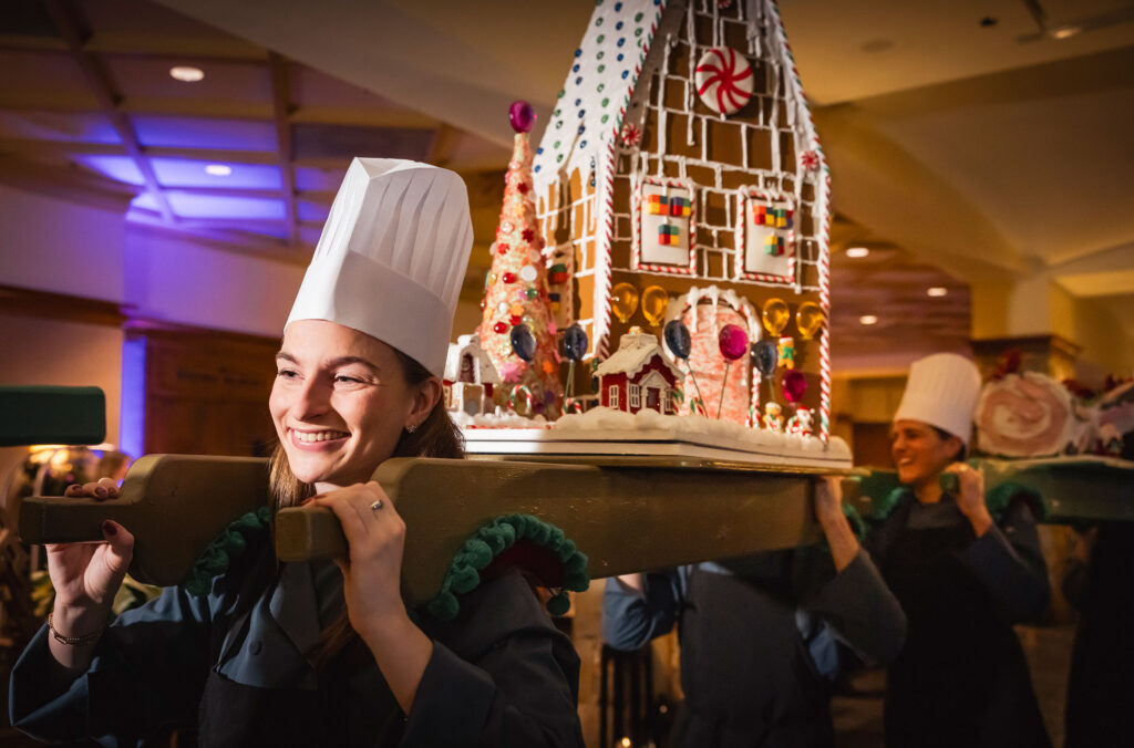 A chef carries a huge gingerbread house through the lobby of the Fairmont Whistler in part of the Christmas Chef's Parade.