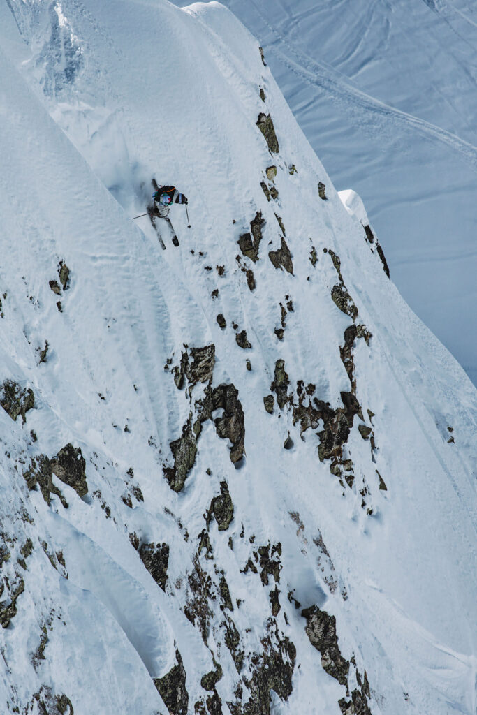 WeiTien skiing a steep, rocky slope during the Freeride World Tour.