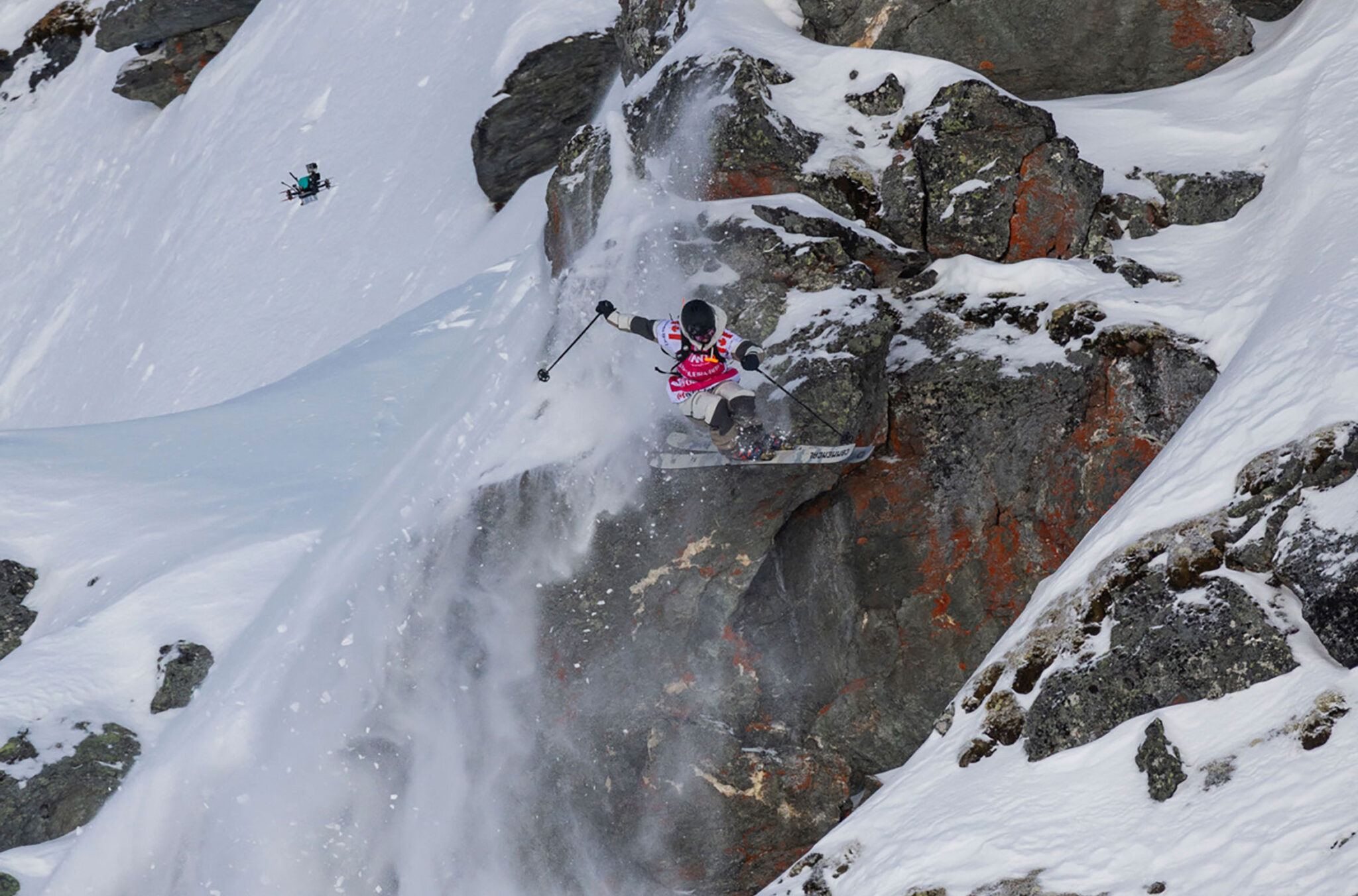 Freeride ski athlete WeiTien jumps off a cliff during a line at the Freeride World Tour comp 2023/24.