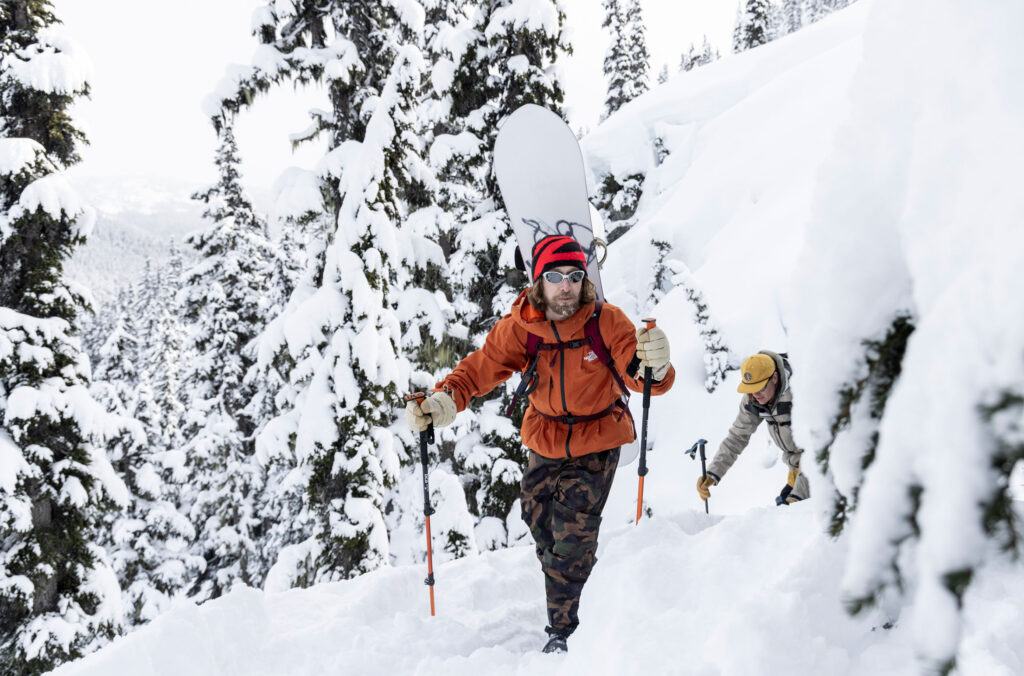 Snowboarder, Brin Alexander hikes in the snowy backcountry of the Callaghan with Bjorn Leines as part of the Natural Selection Duels competition.