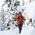 Snowboarder, Brin Alexander hikes in the snowy backcountry of the Callaghan with Bjorn Leines as part of the Natural Selection Duels competition.