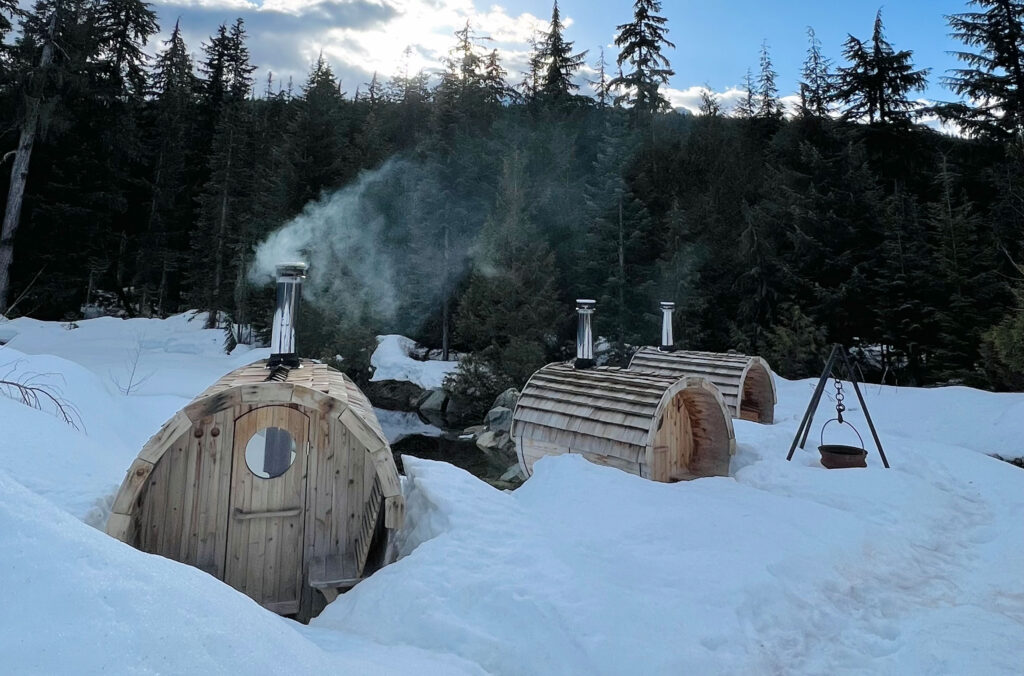 Three barrel saunas sitting in the snow out in the Callaghan Valley part of Canadian Wilderness Adventure's Snowshoe and Sauna Experience.