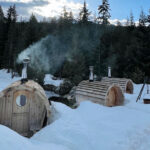 Three barrel saunas sitting in the snow out in the Callaghan Valley part of Canadian Wilderness Adventure's Snowshoe and Sauna Experience.