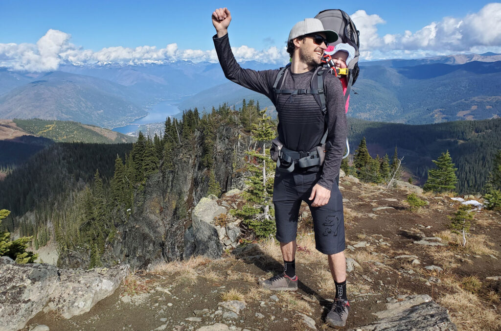 Rich Grenhell hikes in Whistler with his daughter in a pack on his back.