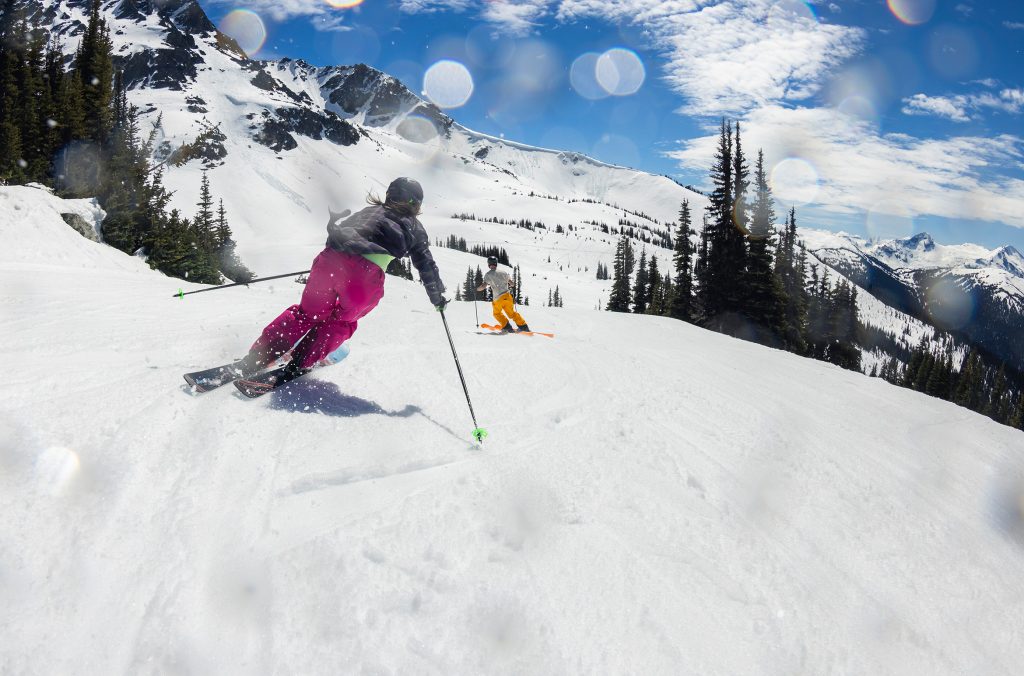 Two skiers enjoy the spring sunshine on the slopes of Whistler Blackcomb.