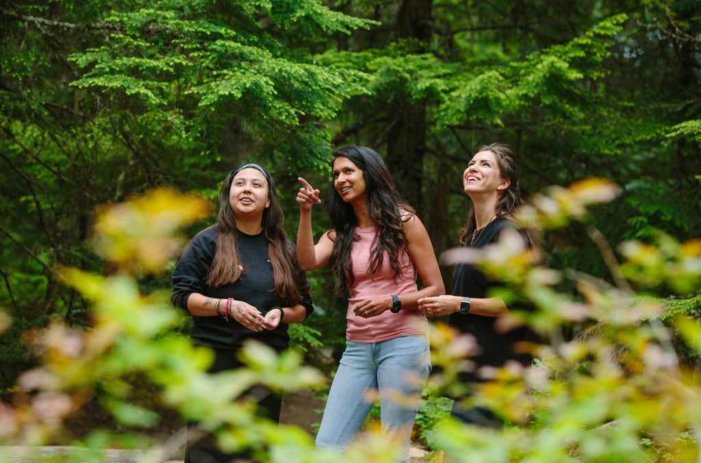 Two people explore Whistler's forest with a Cultural Ambassador from the Squamish Lil'wat Cultural Centre.