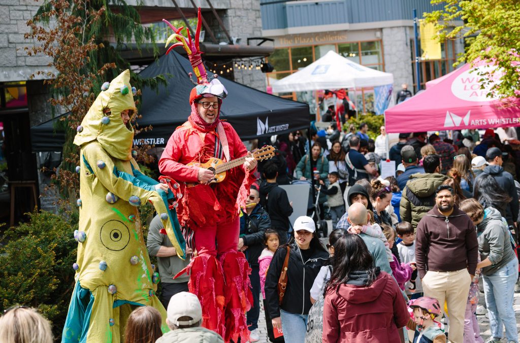 Two stilt performers engage a crowd at the Whistler Children's Festival.