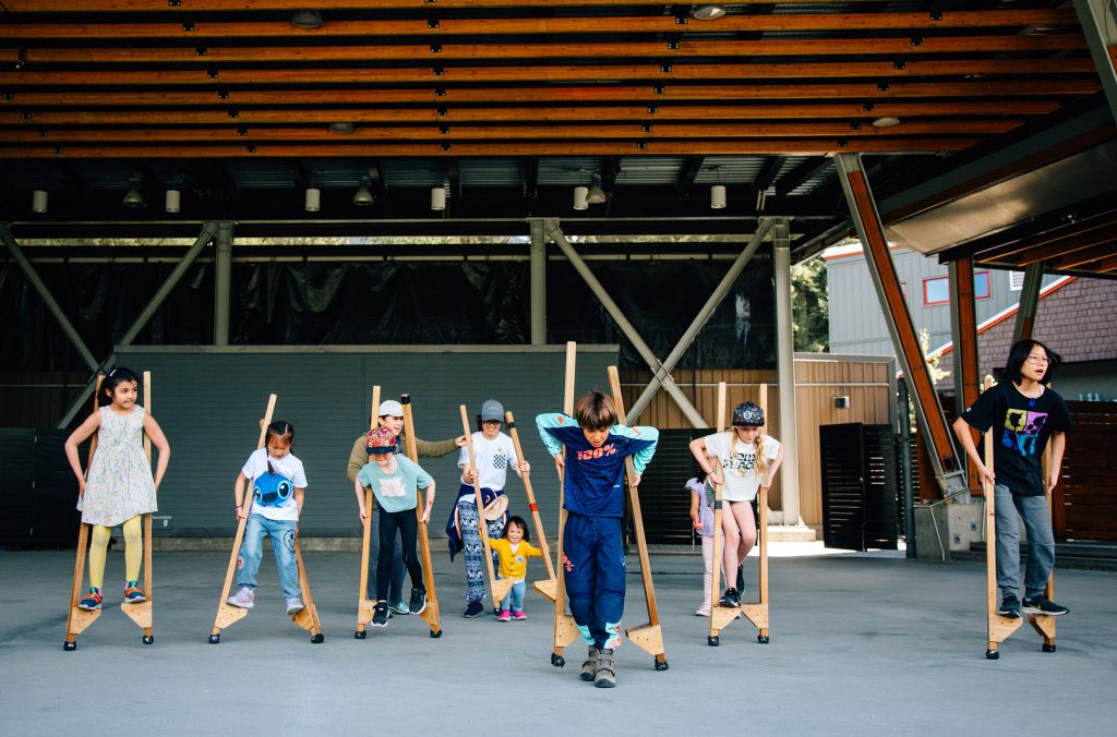 A group of kids learn to walk on stilts at the Whistler Children's Festival.