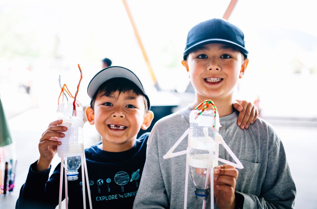 Two kids hold up rockets they'd built at the Whistler Children's Festival.