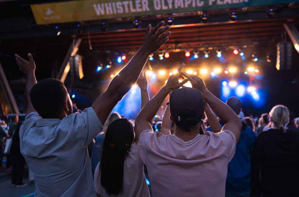 Friends cheer as they listen to the summer concert series in Whistler Olympic Plaza.