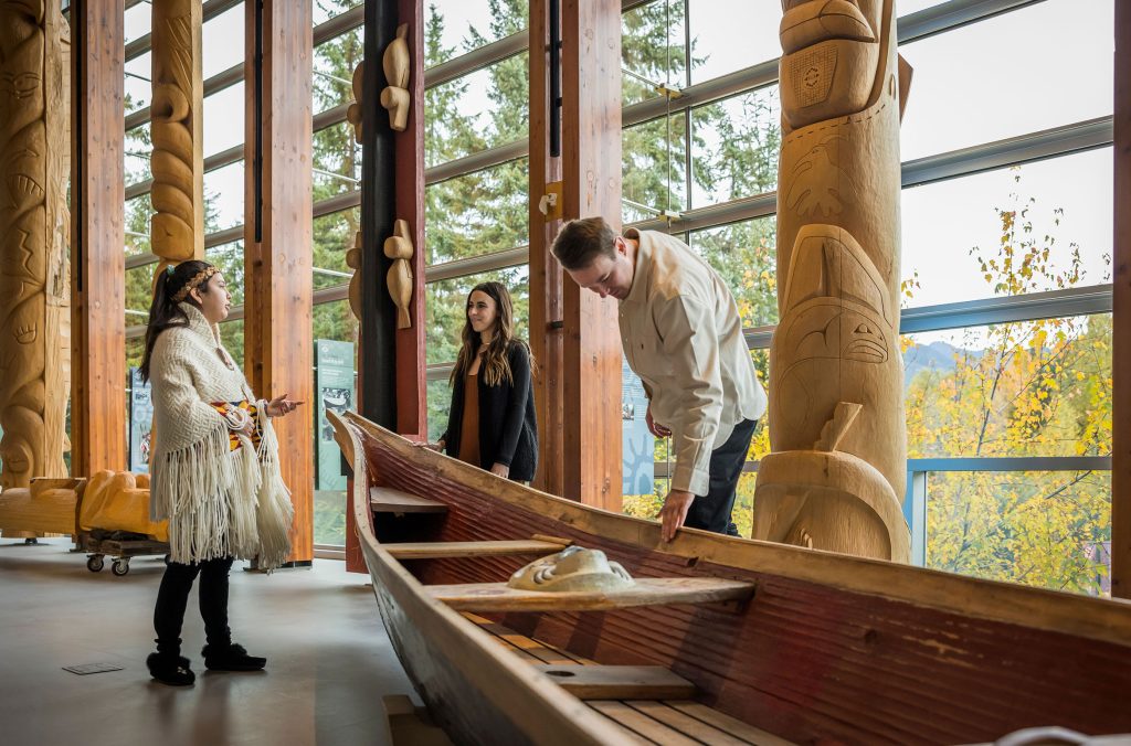 Two people are led on a guided tour of the exhibits at the Squamish Lil'wat Cultural Centre.