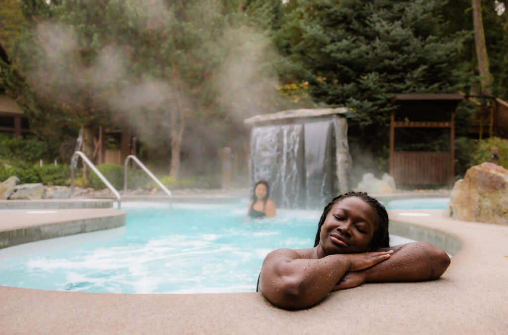 A person relaxes on the edge of a hot pool at the Scandinave Spa in Whistler.