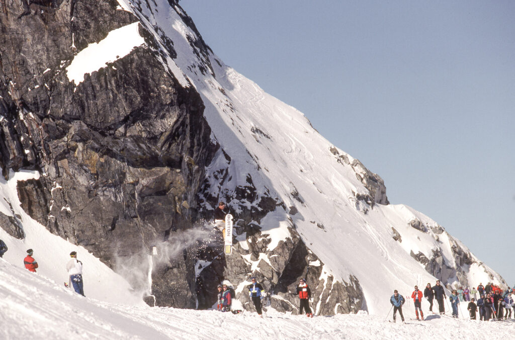 A snowboarder hucks themselves off the Blackcomb Mountain Wind Lip.