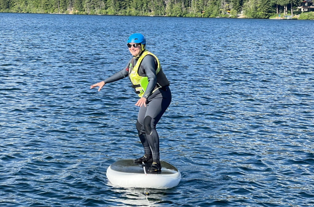 Kate Heskett balances on the board of a wing foil in a lesson on Whistler's Alta Lake.