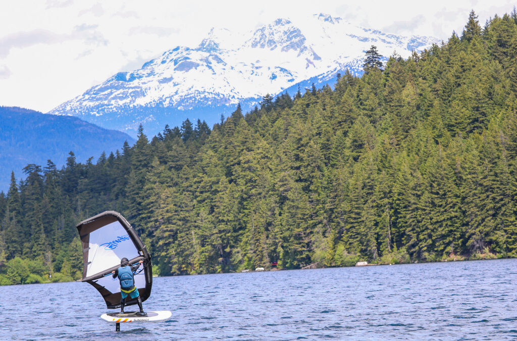 A wing foiler sails across Alta Lake in Whistler.