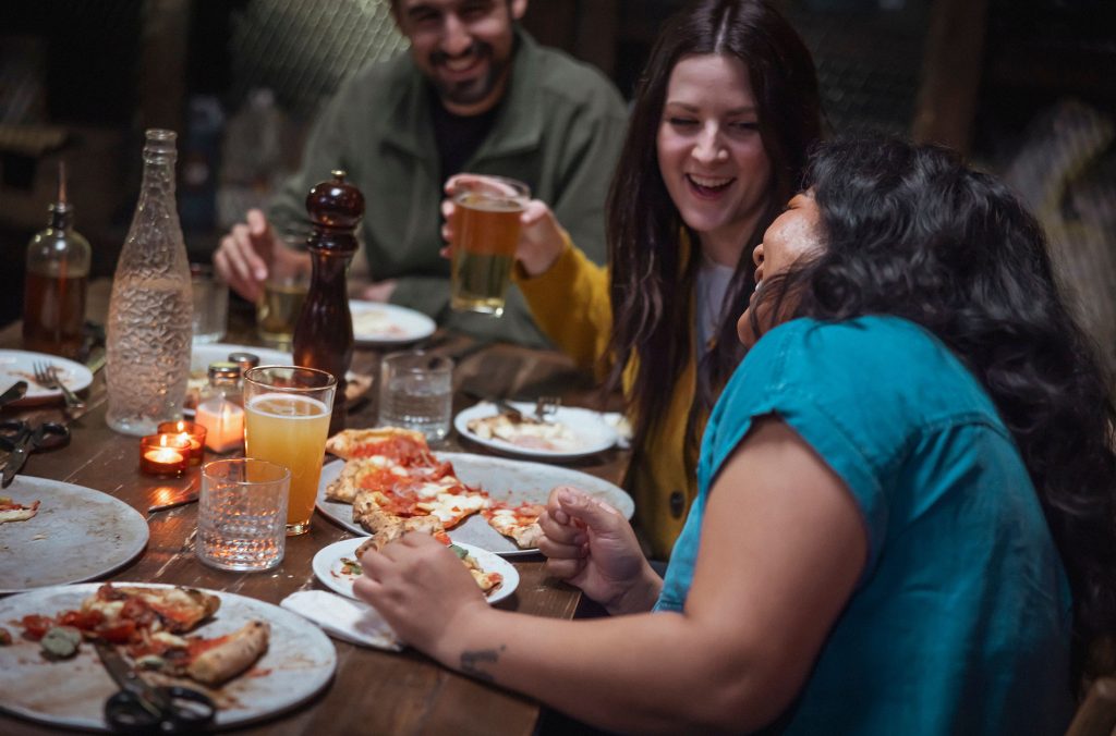 A group of friends enjoy pizza in Whistler.