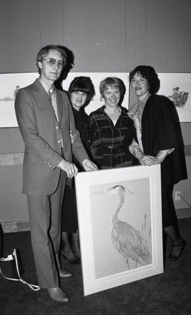 Roy and Olga Tomlinson present "The Blue Heron", a stone lithograph by Roy to Inge Nielsen (organizer of the show) and Glenda Bartosh of the Whistler Community Arts Council. 