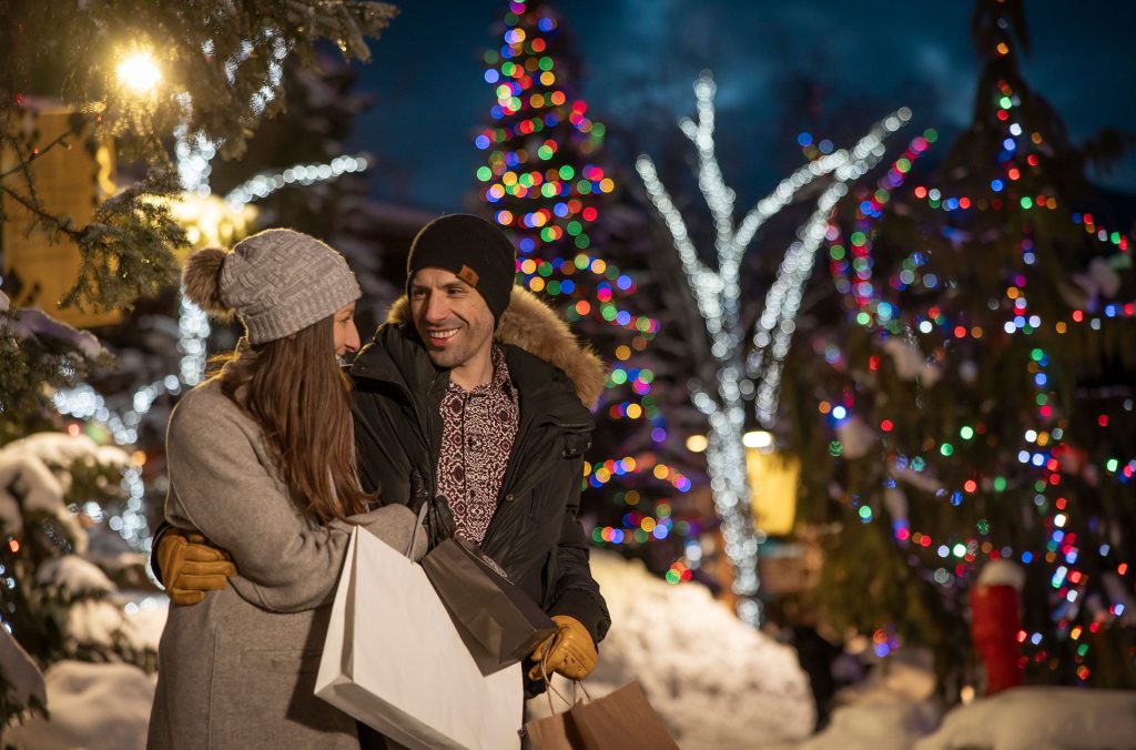 A couple enjoy shopping in the evening in Whistler in the winter.