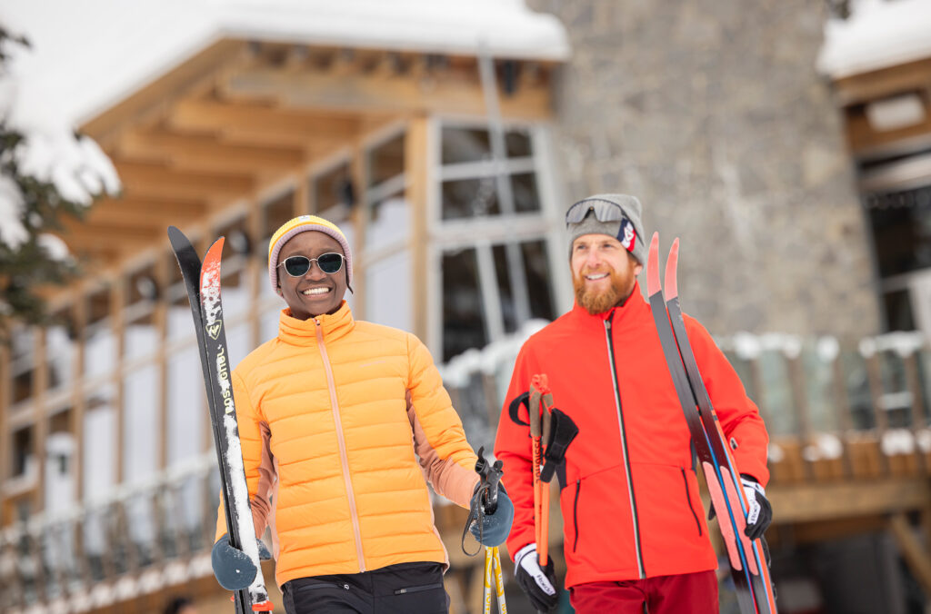 Two people head out with cross-country gear in their hands at Whistler Olympic Park.