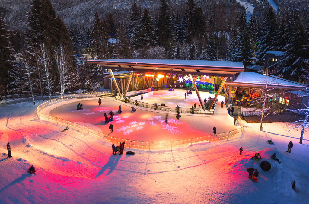 The ice rink at Whistler Olympic Plaza glows pink in the evening light.