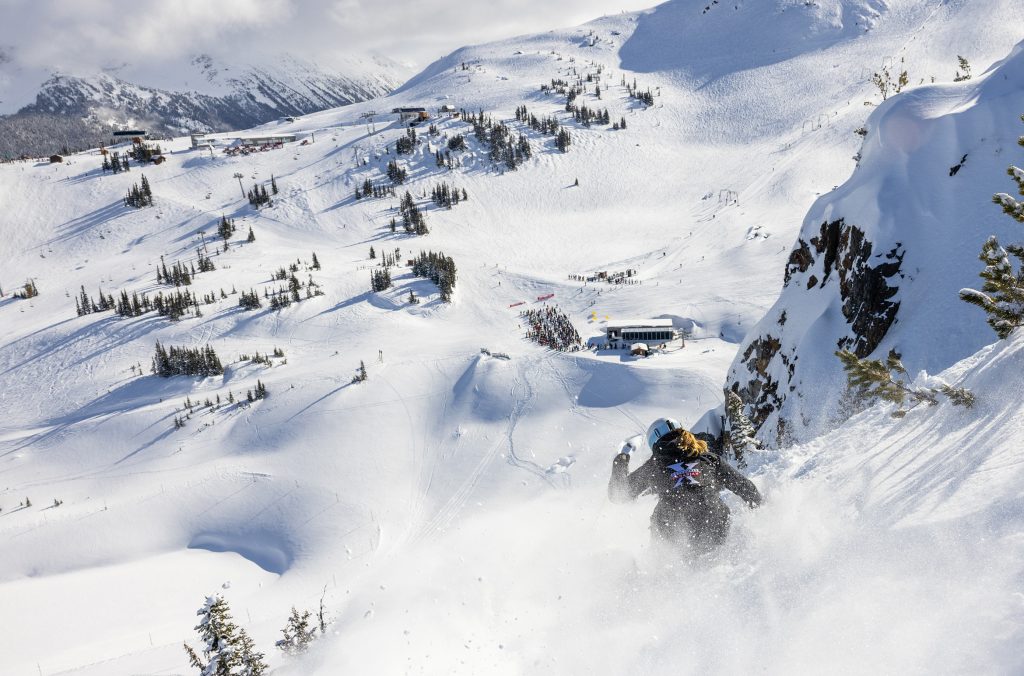A skier makes their way down a steep, snowy slope on Whistler Mountain.