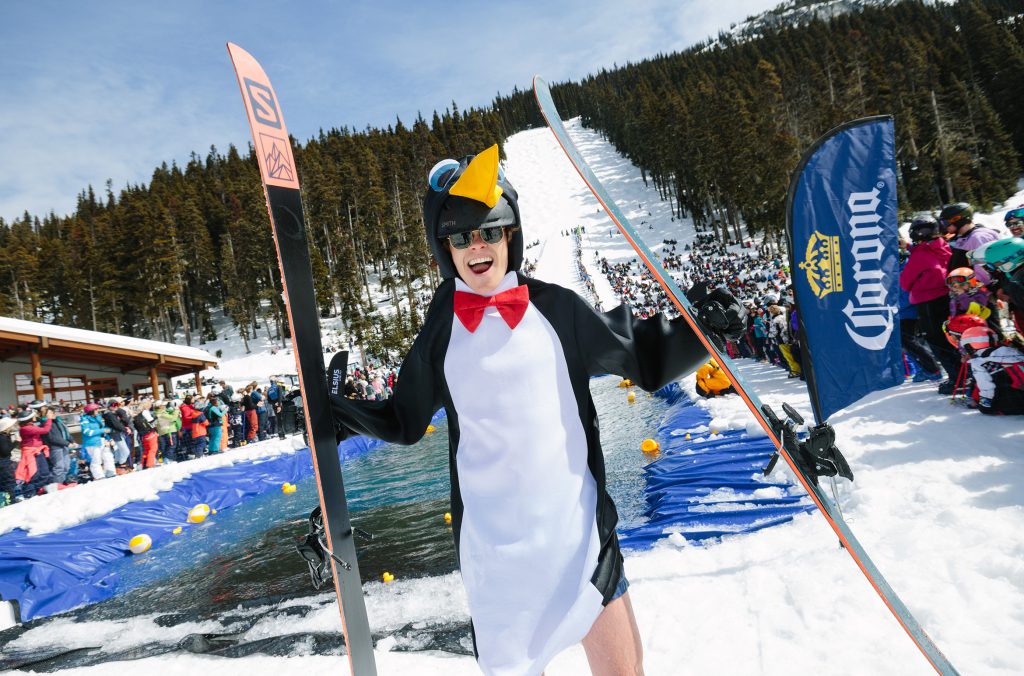 A skier dressed as a penguin looks happy after making it across the waters of the Slush Cup at the World Ski & Snowboard Festival in Whistler.