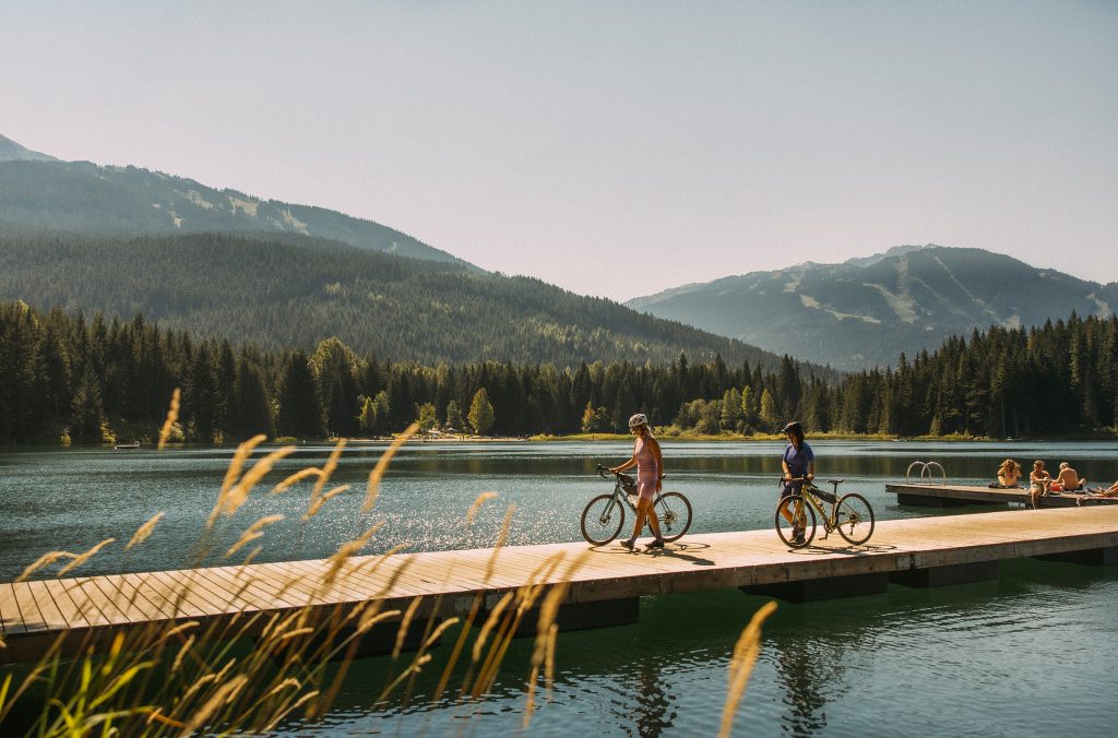 Two bikers explore a lake dock in Whistler in the summer.