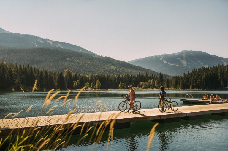 Two bikers explore a lake dock in Whistler in the summer.