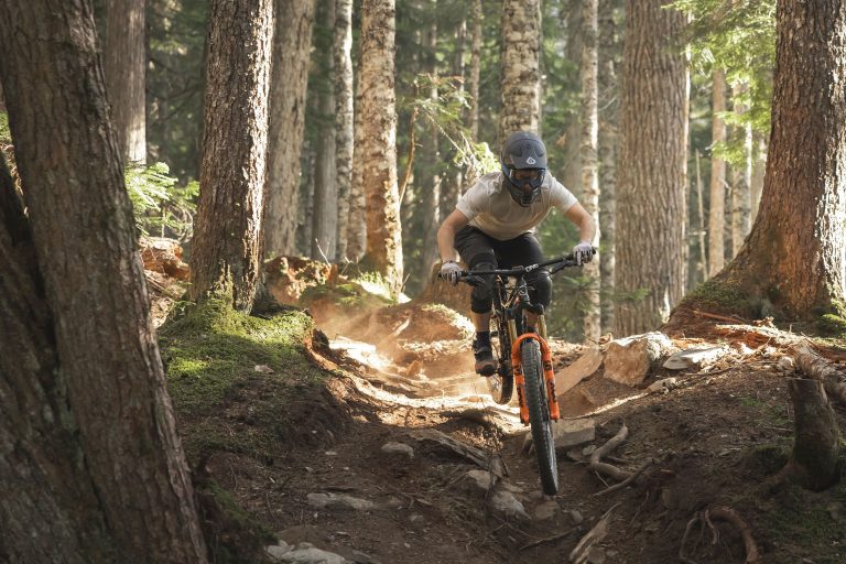 A mountain bike rider tackles roots and rocks on a trail in the Whistler Mountain Bike Park.