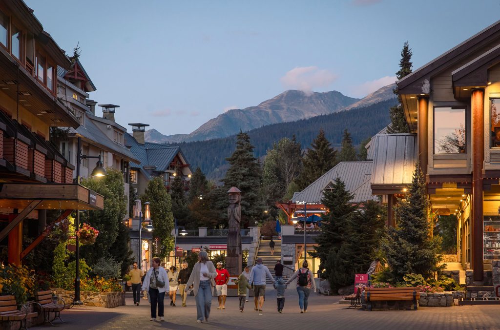 Whistler's Village Stroll glows with light at dusk in the summer.