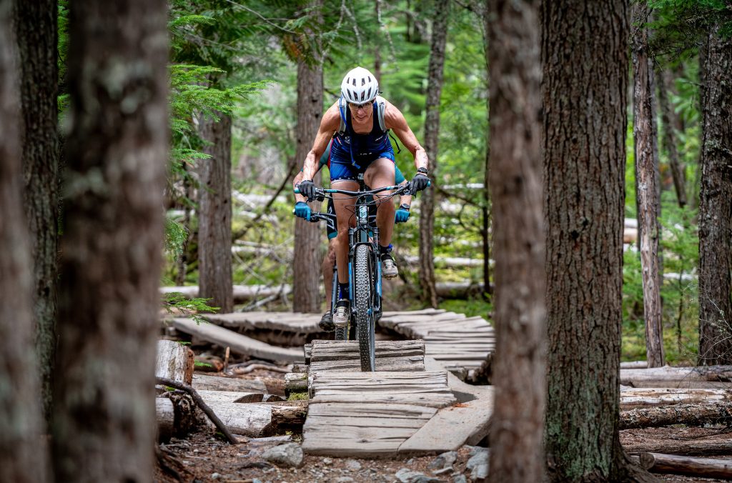 A xc bike rider makes there way across a wooden feature in Lost Lake during the Whistler X Tri.