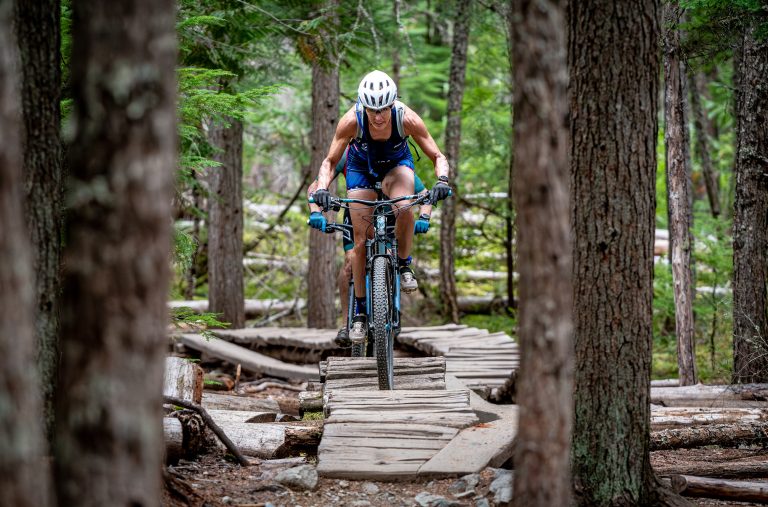 A xc bike rider makes there way across a wooden feature in Lost Lake during the Whistler X Tri.