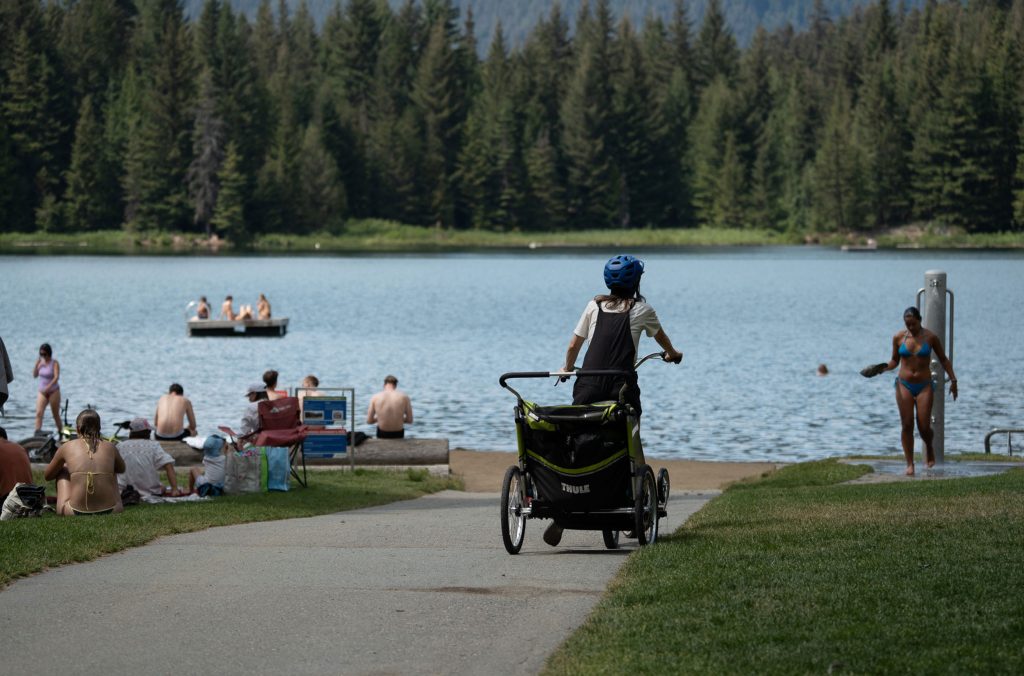 A biker pulls up to Whistler's Lost Lake Park pulling a chariot.