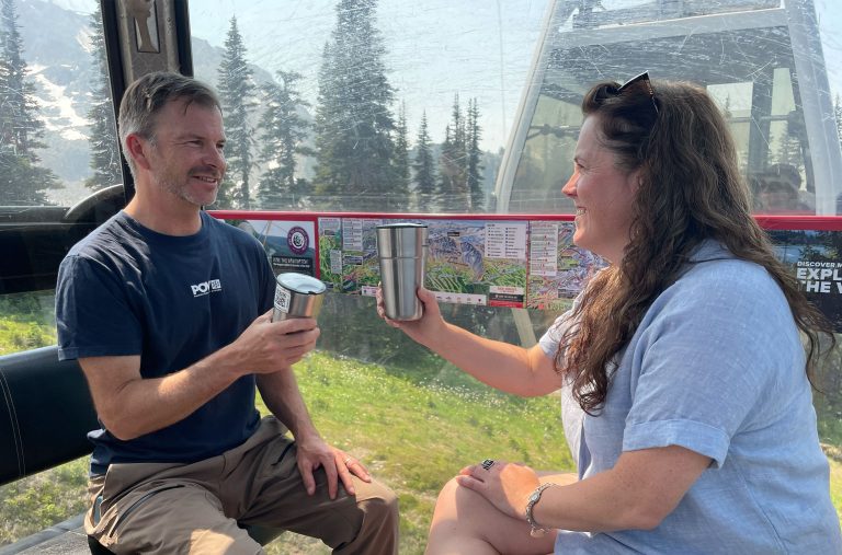 Mike Douglas and Claire Ruddy tap their reusable coffee cups together as they discuss Reuse Whistler in the Whistler Blackcomb gondola.