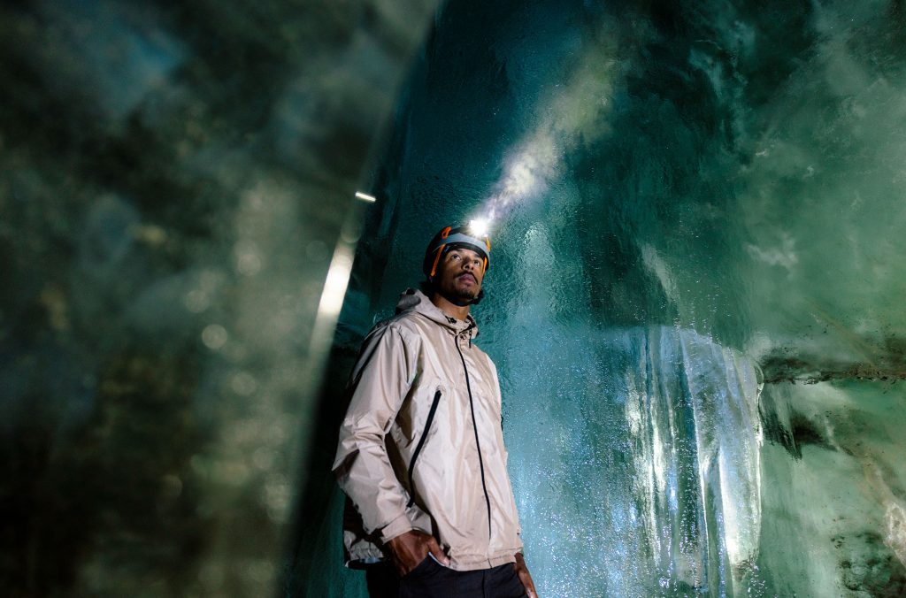 A person looks around on wonder at the ice cave in Whistler.