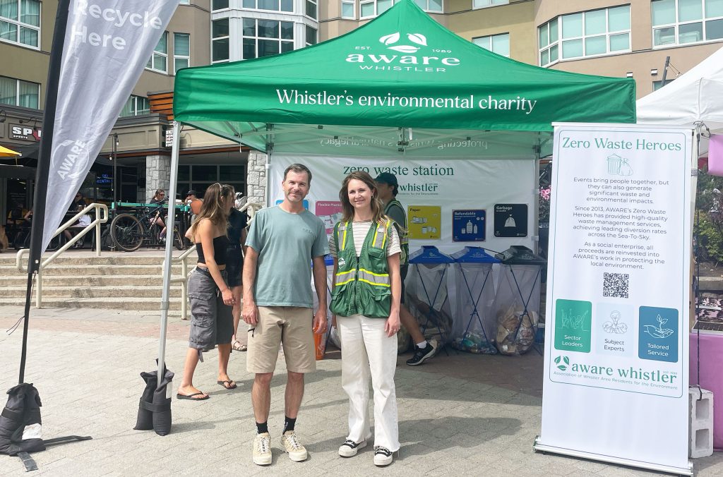 Mike Douglas and Kirsty Smyth stand in front of AWARE's Zero Waste Heroes tent at the Whistler Farmers' Market.