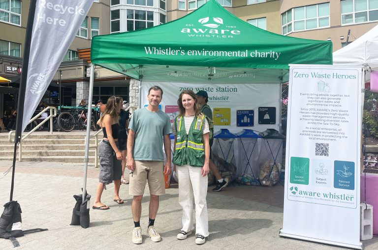 Mike Douglas and Kirsty Smyth stand in front of AWARE's Zero Waste Heroes tent at the Whistler Farmers' Market.