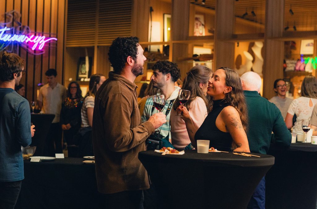 Two people enjoy a glass of wine at an event at the Audain Art Museum.