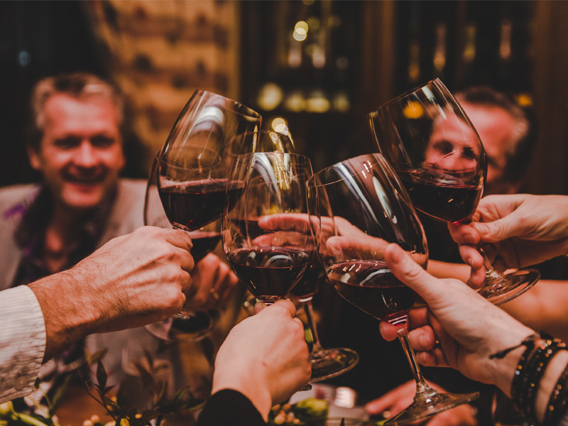 Guests toast with glasses of red wine at the BC House Party during Cornucopia in Whistler.