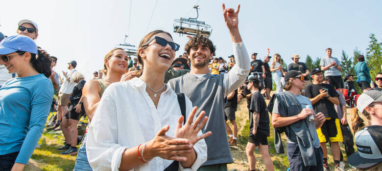 Crowd of spectators cheers at a Crankworx Whistler event, capturing the high-energy atmosphere of the world’s ultimate mountain biking festival.