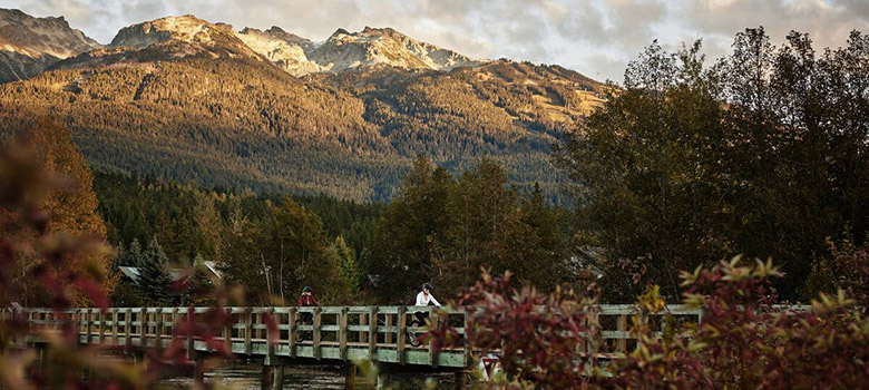 Couple exploring Whistler's Valley Trail by bike in the fall