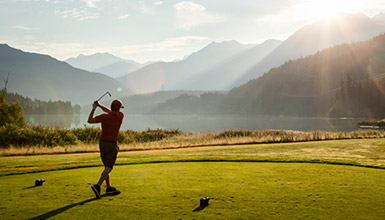 Golfer teeing off at Nicklaus North Golf Course in Whistler